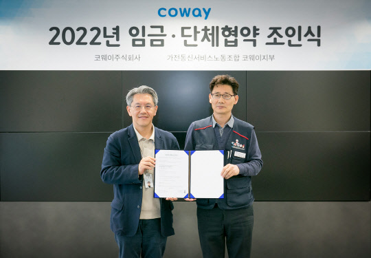 지난 27일 서울 구로구 코웨이 본사에서 진행된 '2022년 임금 및 단체협약 조인식'에서 서장원(왼쪽) 코웨이 대표이사와 임창경 코웨이지부장이 기념사진을 촬영하고 있다. 코웨이 제공